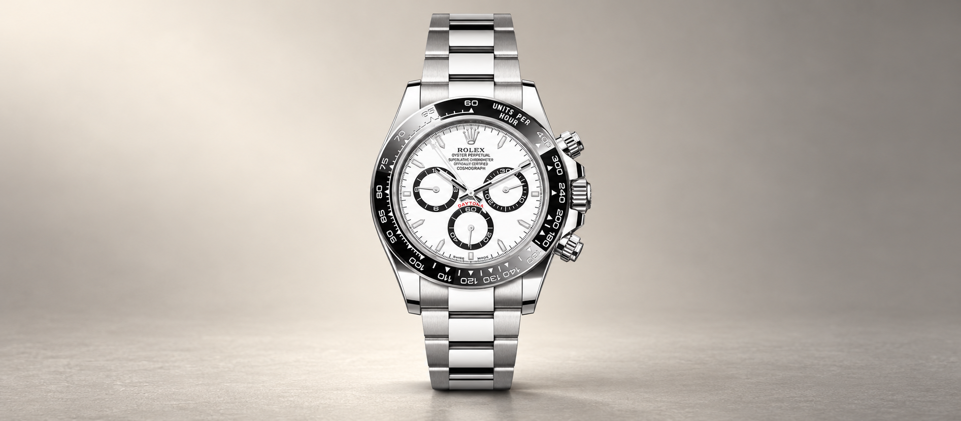 White-dial Rolex Cosmograph Daytona 126500LN with black Cerachrom tachymeter bezel and steel Oyster bracelet on a warm stone-gray background