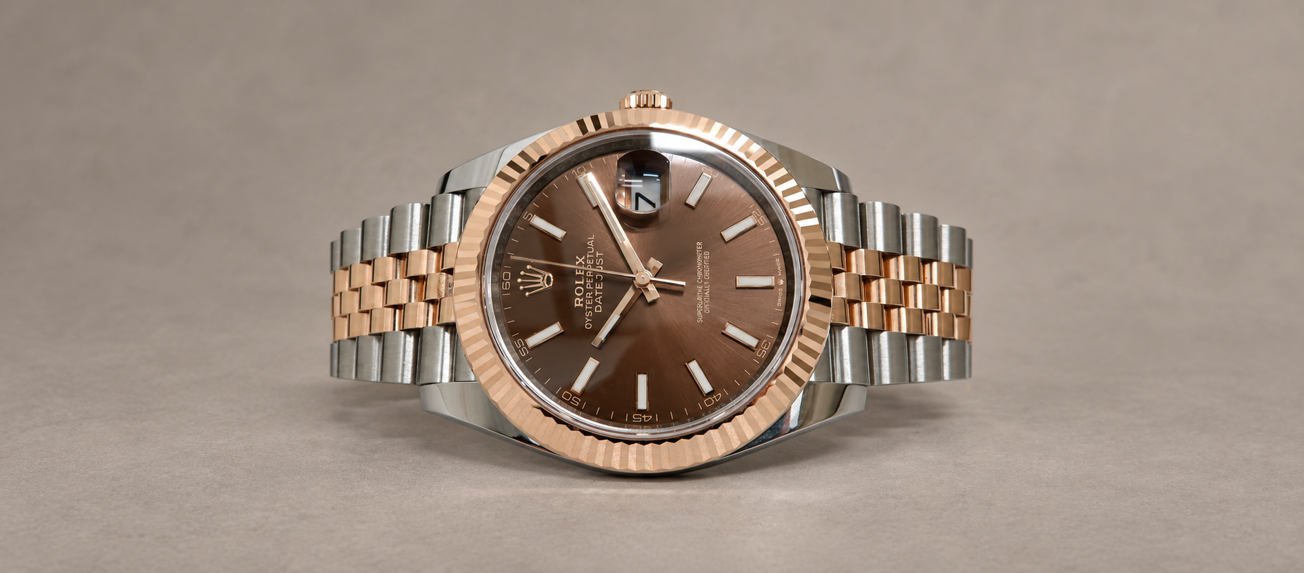 Rolex Datejust 41 reference 126331 with chocolate dial, Everose gold fluted bezel and steel-and-Everose Jubilee bracelet on a taupe background