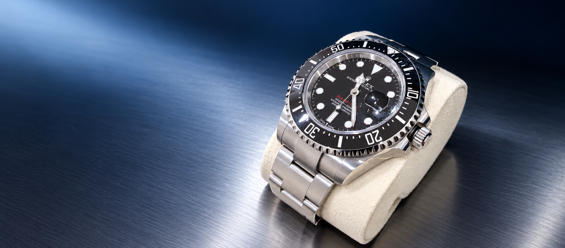 Rolex Sea-Dweller reference 126600 with black dial, red Sea-Dweller text, black ceramic bezel and Oystersteel bracelet on a blue-black studio background